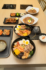 A hearty bowl of seafood noodle soup filled with shrimp, corn, egg, vegetables, rice blood cake,...