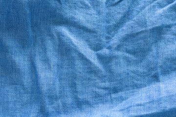 A close-up of a textured, deep blue linen fabric with wavy. abstract background design.