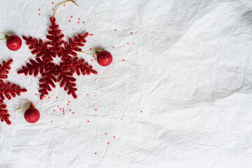 Red Christmas decorations on paper texture background, red star, Christmas ball, and glitters.