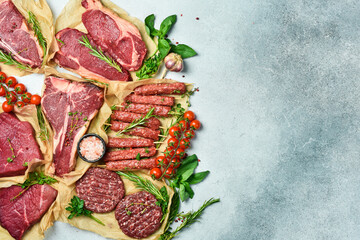 Assortment of meat and meat products. Steak, ribeye steak, kebab and burger patty. On a gray stone...