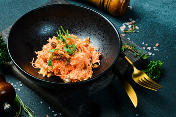 A plate of Homemade salad made of carrots, raisins, garlic and sour cream. On a black stone...