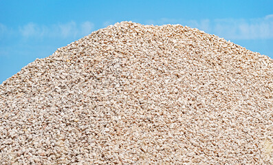 Piles of fine gravel against clear blue sky.