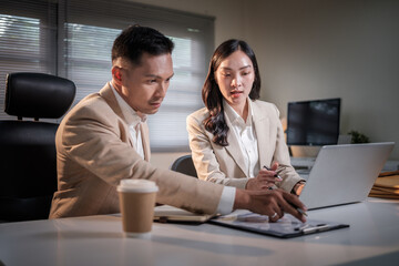 Focused business teamwork session between a man and woman discussing data and strategy.