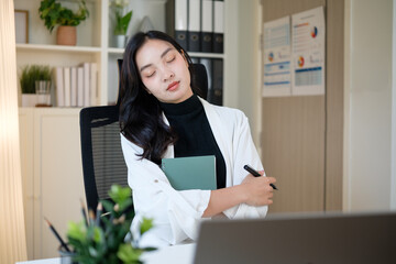 Tired businesswoman resting with closed eyes during remote work at home office.