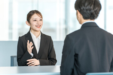 スーツ姿の男性を取材するインタビュアー,マスコミ,記者の女性
