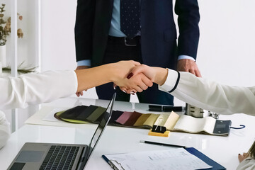 Business professionals engage in a handshake during a meeting in a modern office