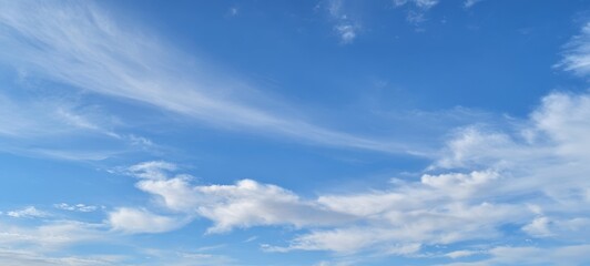 Obraz premium The Serene Blue Sky with Fluffy Clouds and Bright Sunlight