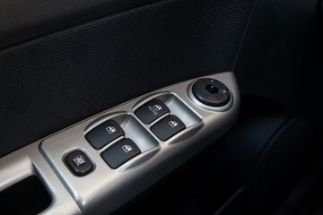 Close-up of the side door buttons: window adjustment buttons, door lock. Window control panel in a...