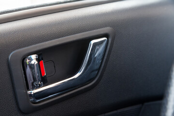 A close-up view of a part of the interior of a modern luxury car with a view of a silver-colored...