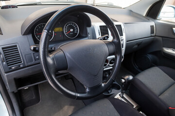 Comfortable front seats inside the car: the driver and passenger, tied with black fabric trim,...