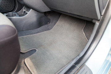 Clean car floor mats of black carpet under front passenger seat in the workshop for the detailing...