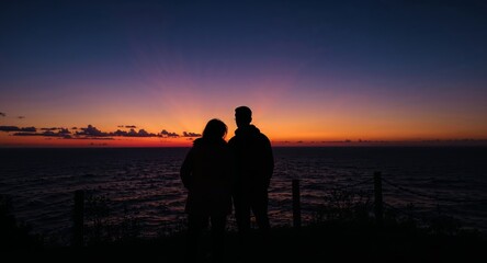 Silhouette Couple Gazing at a Breathtaking Sunset Over the Sea Horizon.