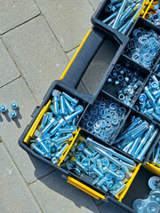 Toolbox full of bolts and nuts on the ground in the street