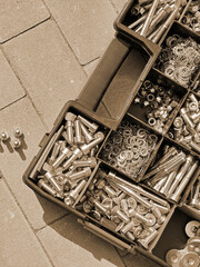 Toolbox full of bolts and nuts on the ground in the street