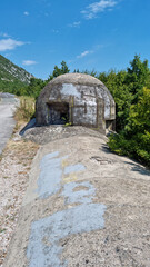 Fototapeta premium A two-story Italian World War II bunker on the road above Krizisce in Croatia, overlooking the surrounding hilly landscape under a clear sky