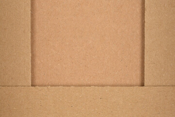 A close-up, top-down view reveals the textured brown surface of a cardboard box interior with...