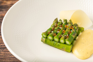 Steamed asparagus with hollandaise sauce and decorative potatoes