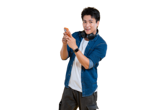 Young man holding a mobile phone, possibly taking photo or using app while headphones around his neck. Dressed casually with a light smile, and smartwatch  on png background