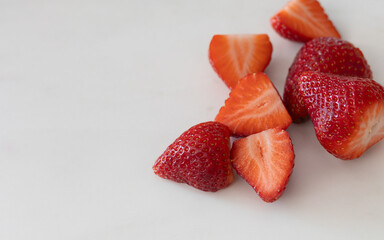 Close up of fresh ripe strawberries and slices on white background for healthy food and lifestyle...