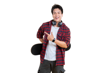 A young man holding a skateboard, pointing at something with a smile on his face. He is wearing a plaid shirt and headphones around his neck on png background