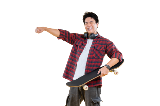 A young man holding a skateboard, smiling and pointing towards something on png background