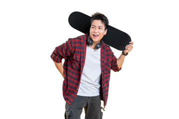 A young man wearing a red and black checkered shirt, holding a skateboard, with headphones around...