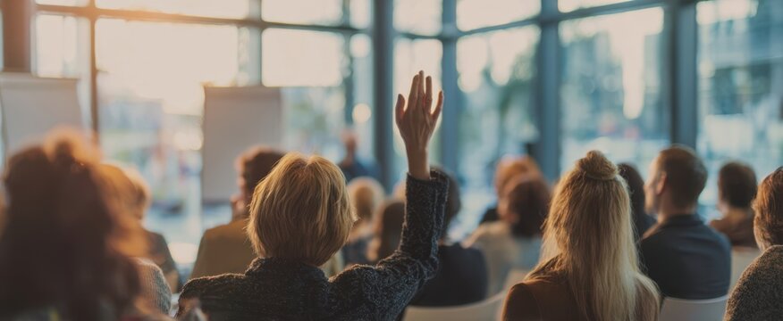 The engaged audience raising hands during a corporate training session.