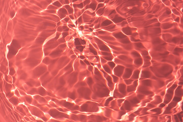 Red water with ripples on the surface. Defocus blurred transparent white colored clear calm water surface texture with splashes and bubbles. Water waves with shining pattern texture background.