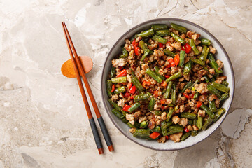 Pork mince fried with green beans, bell pepper, garlic, ginger and soy sauce close-up in a bowl on...