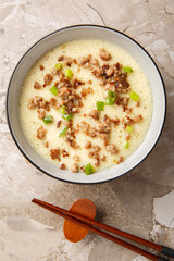 homemade steamed egg with crispy minced pork and green onion closeup in the bowl on the table....