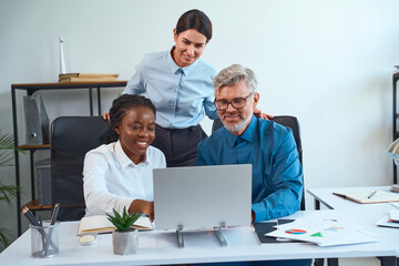 Team Collaborating At Office Desk, Diverse Professionals Working Together, Smiling And Sharing...