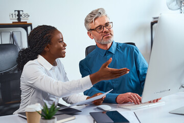 Colleagues Collaborating In A Modern Office Environment, Discussing Ideas And Analyzing Information...