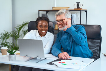 Business Colleagues Collaborating On a Project in a Modern Office Setting, Smiling and Engaged With...