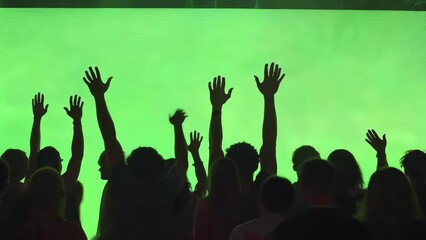 silhouettes of a crowd of people with hands raised on a green screen background - Powered by Adobe