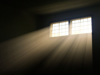 Dramatic sun rays piercing through a window into a dark room, creating striking light and shadow. Ideal for themes of hope, mystery, interior atmosphere, or spirituality.