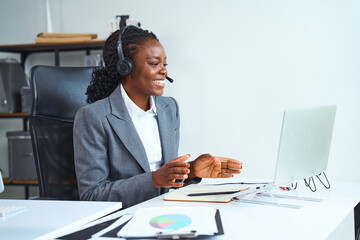 Smiling Business Professional Conducting Virtual Meeting, Using Headphones And Laptop At Modern...