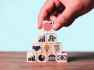 Business Strategy Concept – Hand Placing Target Icon Block on Pyramid of Success Symbols