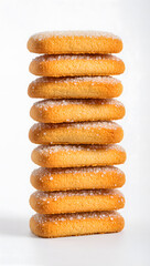 Golden brown sugar coated biscuits stacked neatly, isolated on white background