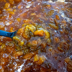 jam in a large saucepan. plum jam. apricot jam. Boiling apricot jam in a saucepan, view from above. Fragrant orange berries and foam in a saucepan on the stove.