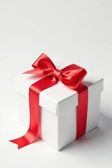 Obraz premium A pristine white gift box adorned with a vibrant red ribbon, a symbol of celebration and thoughtful presentation