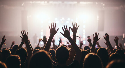 Enthusiastic crowd with raised hands at a concert.