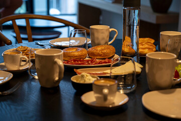 Breakfast prepared at the table with cheese bagels and coffee ready to enjoy with the family.