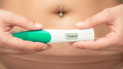 Pregnancy test with positive result on table