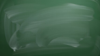 Abstract chalk smudges on a green chalkboard, a textured background for creative ideas and learning.