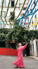 Naklejka premium A tourist in a bright dress dances during a carnival on the streets of Lisbon. Soft focus