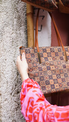 A tourist in a bright dress looks at cork bags on the streets of Lisbon. Soft focus