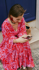 A tourist in a bright dress talks on a video call on the street of Lisbon.soft focus