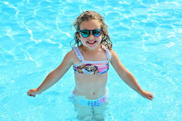 Happy little girl in the swimming pool