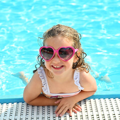 Happy little girl in the swimming pool