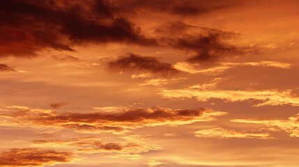 Obraz premium A golden sunset sky with orange and yellow clouds in high definition, vibrant gold hues adding depth, reflecting warmth and tranquility on the ground for an atmospheric natural backdrop.